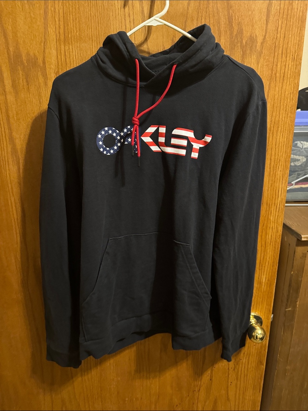 Oakley Black Pullover Hoodie with American Flag Logo and Red Drawstrings